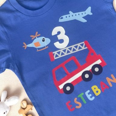 T-shirt bleu avec un hélicoptère, un avion, un camion de pompiers et le numéro 3.