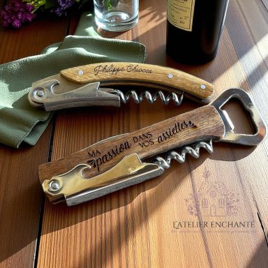 Tire-bouchon en bois avec outil à bouteille, gravé et élégant, posé sur une nappe.