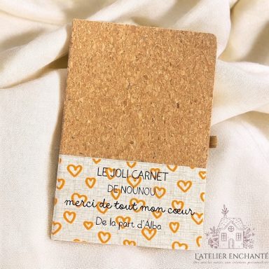 Carnet en liège avec une bande décorative à cœurs orange et un message inspirant.